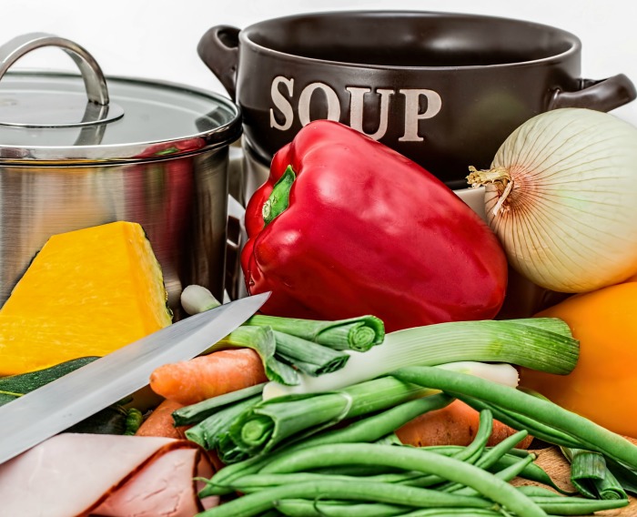 soup pot, soup bowls, knife and vegetables Making a pot of soup
