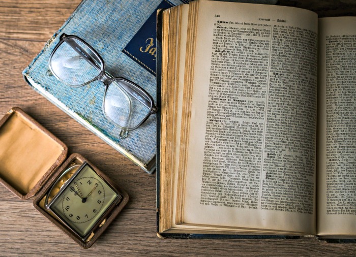 Old book, clock and glasses