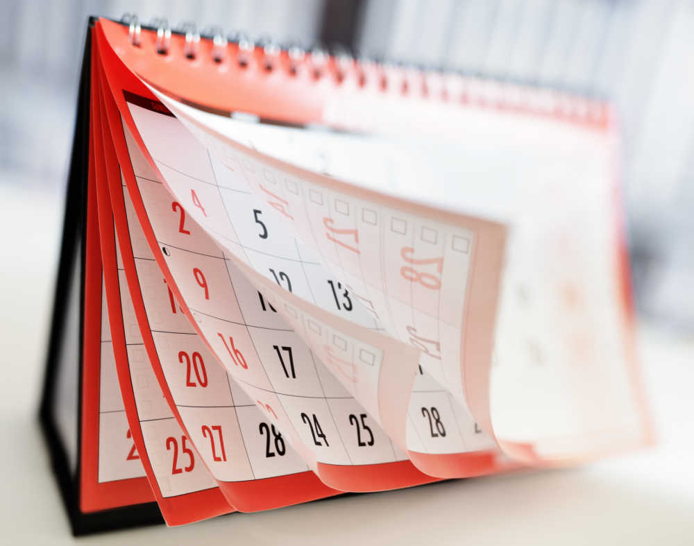 Get your printable calendars! Pages of a red calendar opening up.