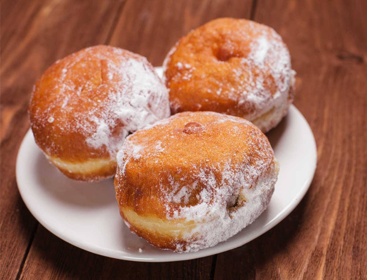 Jelly donut day! Food holidays in June: Jelly filled donuts on a white plate.