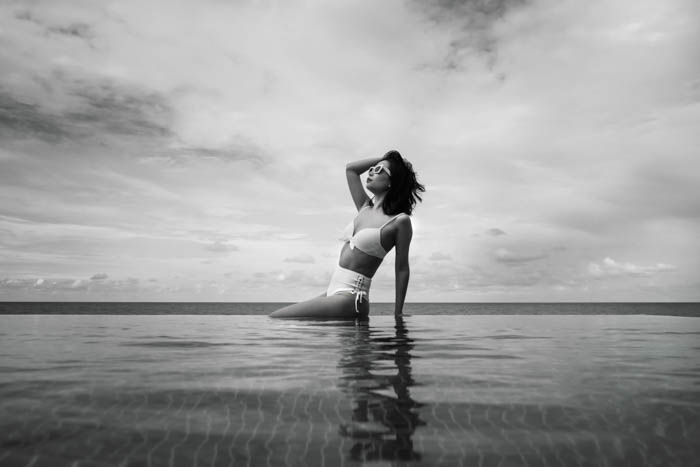 a black and white photo of a woman wearing a vintage white bikini old photo of a woman sunbathing in a white bikini