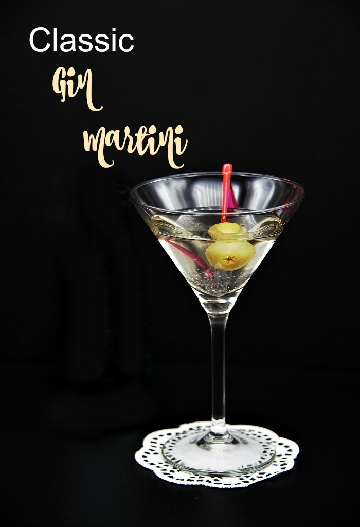 Classic Gin martini with olives and text overlay The classic gin martini is garnished with olives