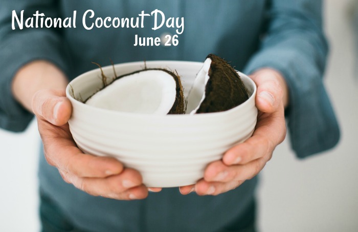 Man holding a white bowl of coconut with the words "national coconut day - June 26" A person holding a white bowl with coconut in it with a text overlay at the top of the image that says National Coconut Day June 26.