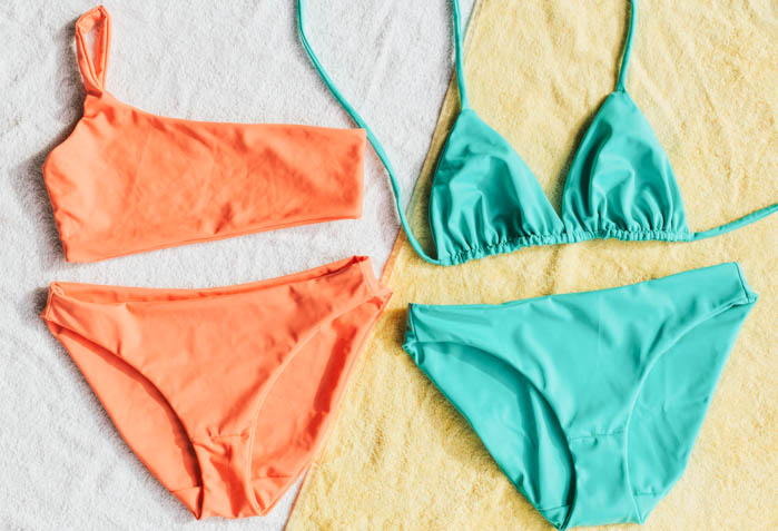 two pairs of bikinis, one is a neon orange bikini and the other is a neon green bikini two pairs of neon bikinis