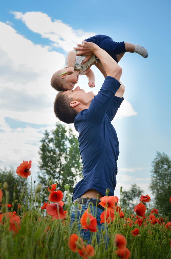 loving father and son in a field of flowers reminds us about be a kid again day