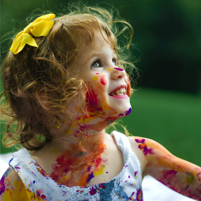 Little girl with paint on her face and clothes