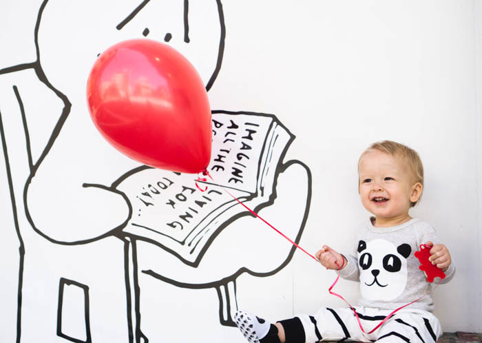 A little boy holding a red balloon in his toy room a child holding a balloon