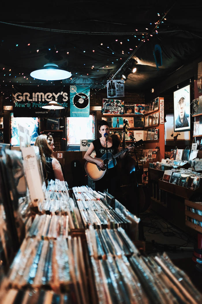 a woman celebrating national record day by performing live music in a record shop celebrate national record day