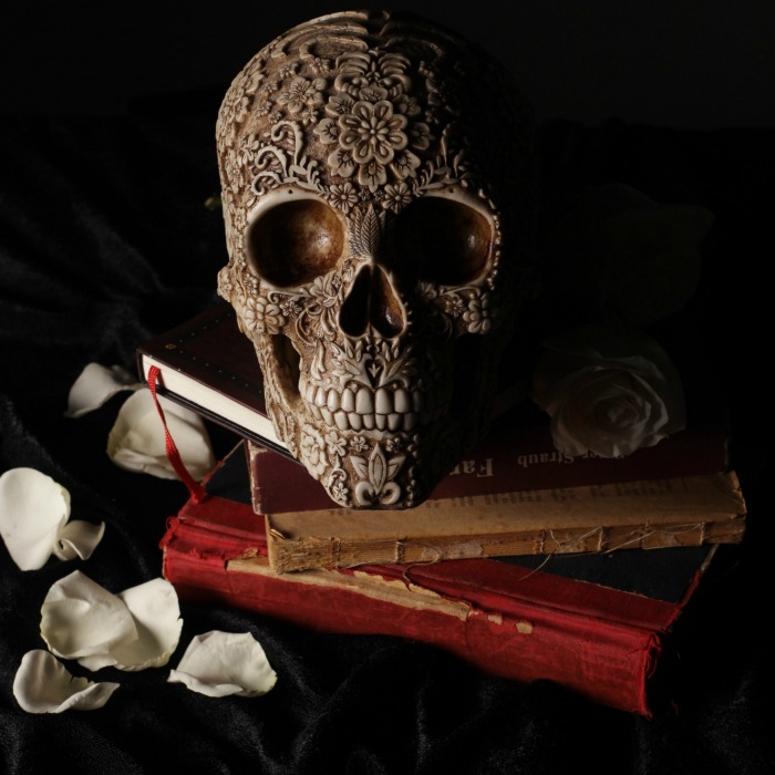 DIY Halloween decoration with a skull, books and rose petals