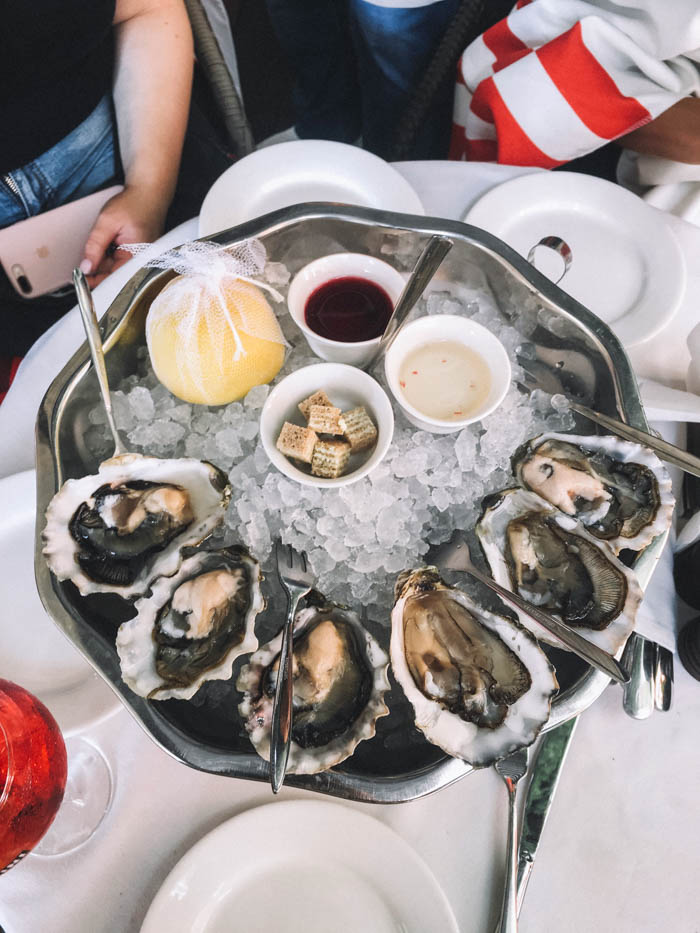A plate of raw oysters on ice with sauces and lemon. raw oysters on ice with sauces and lemon to celebrate National Oyster Day