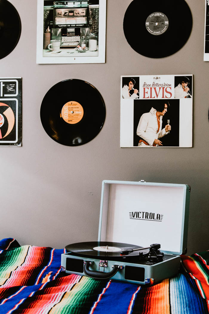a collection of vinyl records on a wall over a record player vinyl collection record display