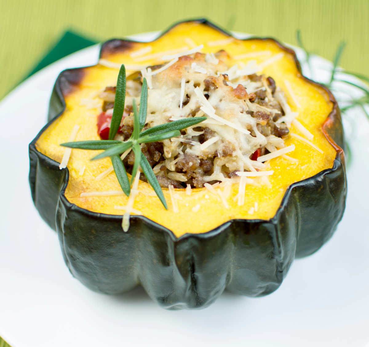 Stuffed acorn squash for Acorn Squash Day Acorn squash on a white plate with filling.