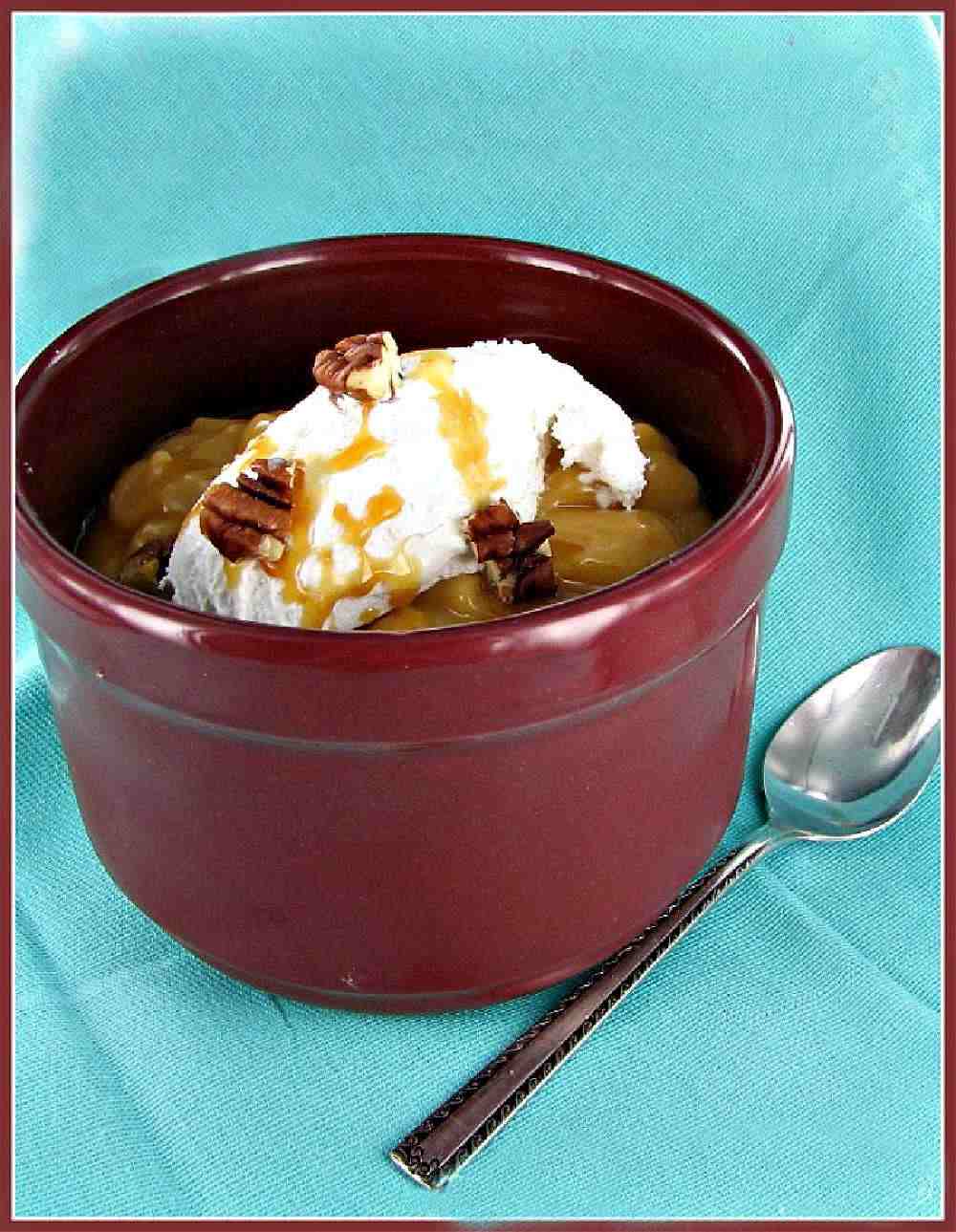 Butterscotch pudding day Butterscotch pudding and whipped cream in a burgundy colored bowl.
