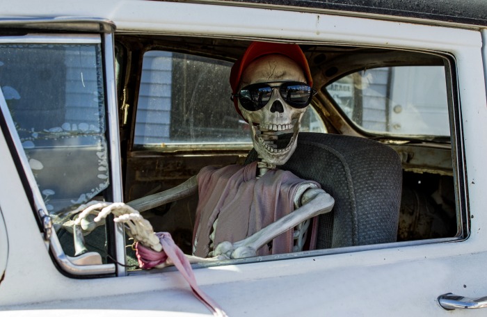 Sporty car skeleton! Skeleton in a pink dress sitting in a car.