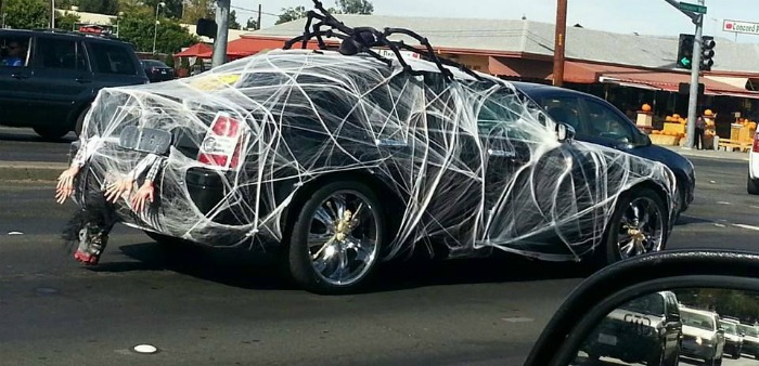 Black spider web car. Car covered in spider webs and a giant spider.