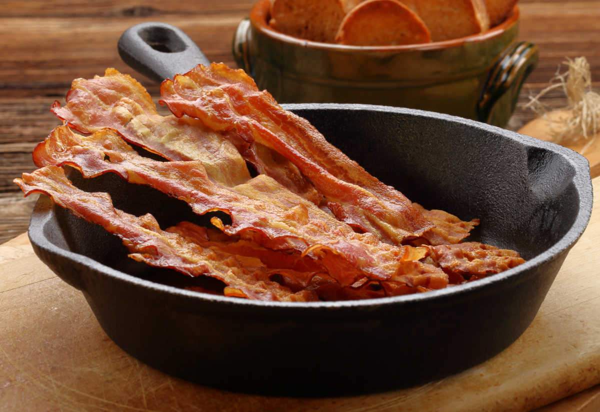 Cooked bacon for international bacon day Cooked bacon in a cast iron pan.