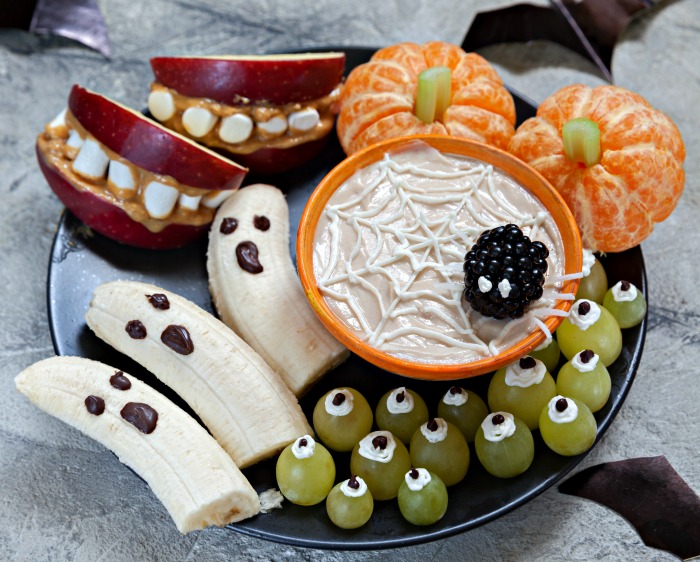 Healthy Halloween snack plate Healthy Halloween snack plate with orange pumpkins, banana ghosts, grape eyeballs and mouth apples.