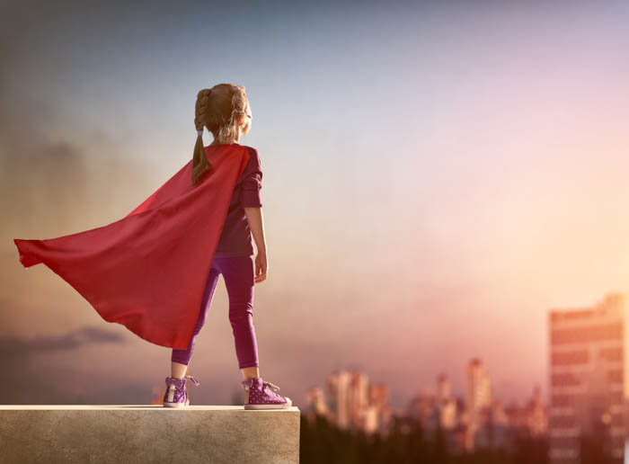 A girl dressed as a superhero looking out over the city. A girl dressed as a superhero looking out over the city.