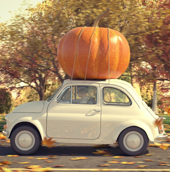 Halloween car decorations: Small beige care with a large pumpkin.