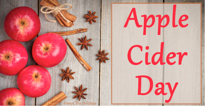 An overhead view of apple cider ingredients with a text overlay reading "apple cider day". An overhead view of apple cider ingredients (apples, cinnamon sticks and star anise) with a text overlay reading "apple cider day".