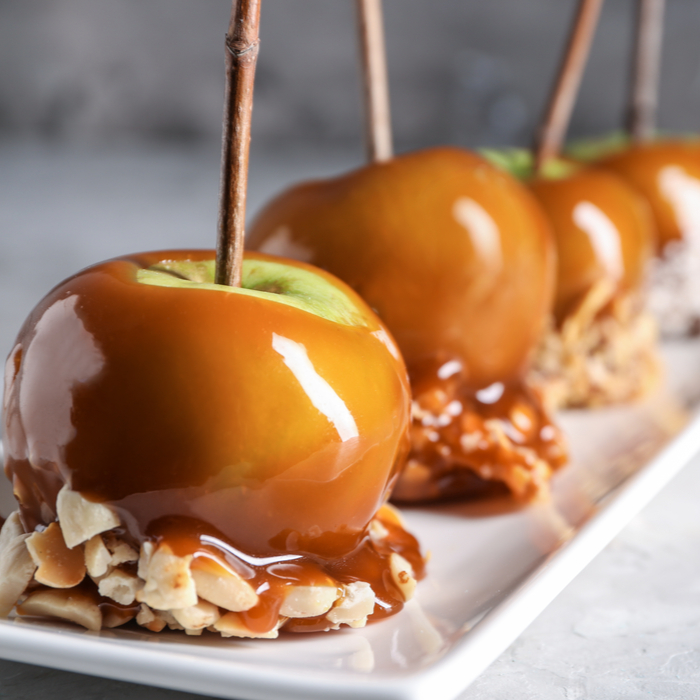 A plate of homemade caramel apples with an almond topping.