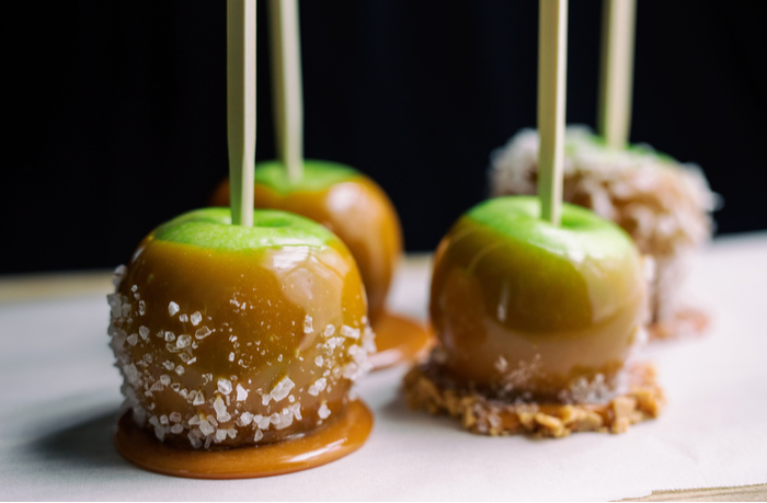Salted caramel apples. Four Granny Smith salted caramel apples on a plate.