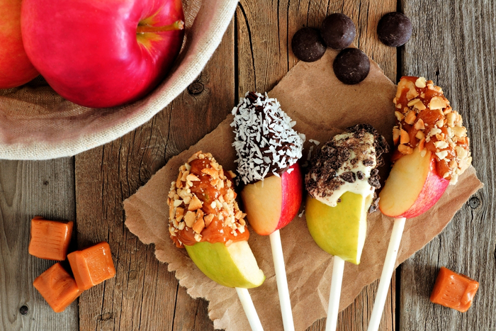 Caramel apple slices with different toppings. Fun caramel apple slices with different toppings surrounded by caramel apple toppings and apples.