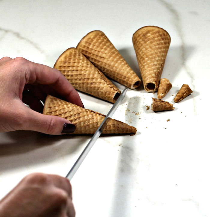 Cutting off the ends of sugar cubes. Female hand cutting off the tips of sugar cones.