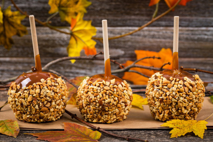 Fall themed caramel apples with peanuts. Rustic fall themed caramel apples with peanuts surrounded by fall decorations.