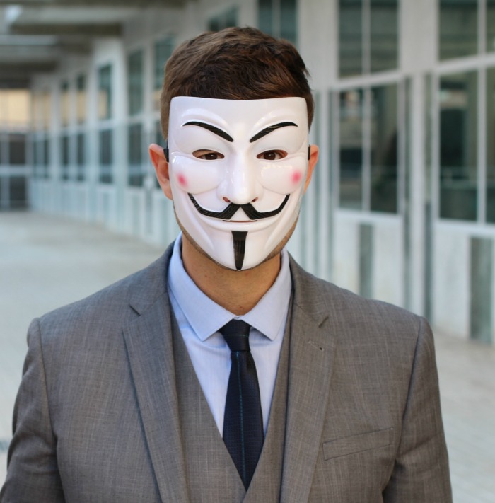 Man wearing a white Guy Fawkes mask.
