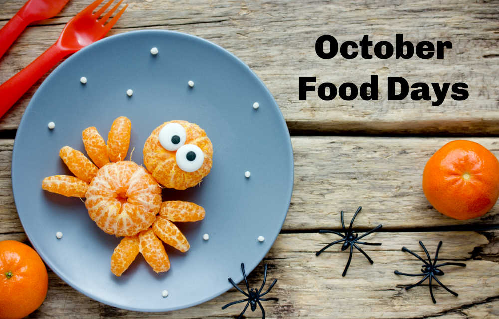 A black text overlay reading October food days on the right side of the image, with a blue plate on the left with a spider whose body is made entirely of mandarin oranges with edible eyes on top on the plate.