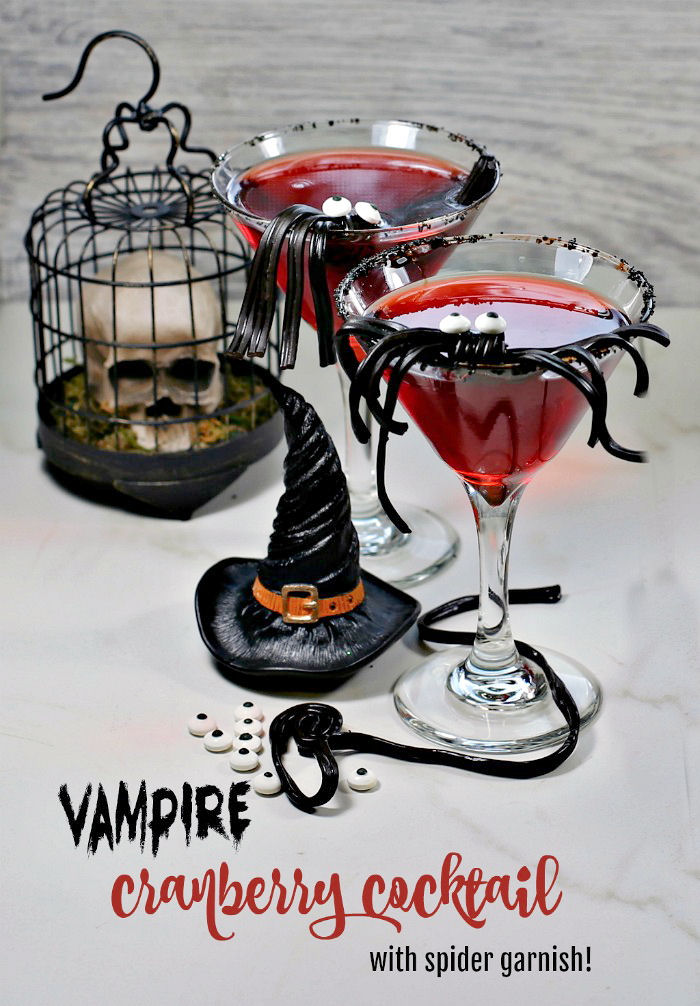 Spider cocktails for Halloween Two red Halloween drinks with spider garnishes sitting beside a skull and witch hat with words vampire cranberry cocktail with spider garnish in red and black text below them.
