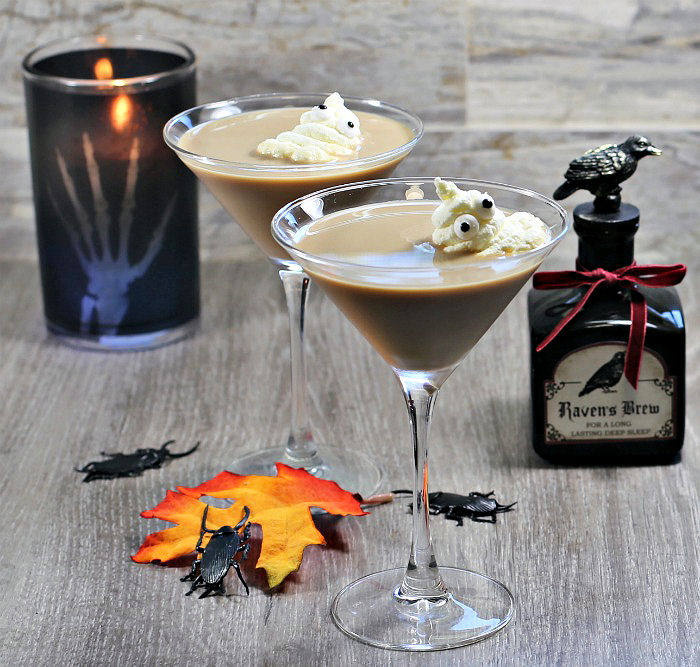Ghostbuster cocktails. Whipped cream ghosts in a creamy drink, with black candle leaves and bottle of potion.