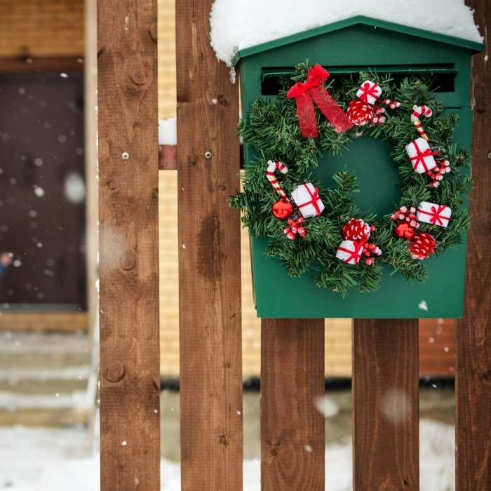 Antique letter box decorated for the holidays. Antique green letter box with Christmas decorations.