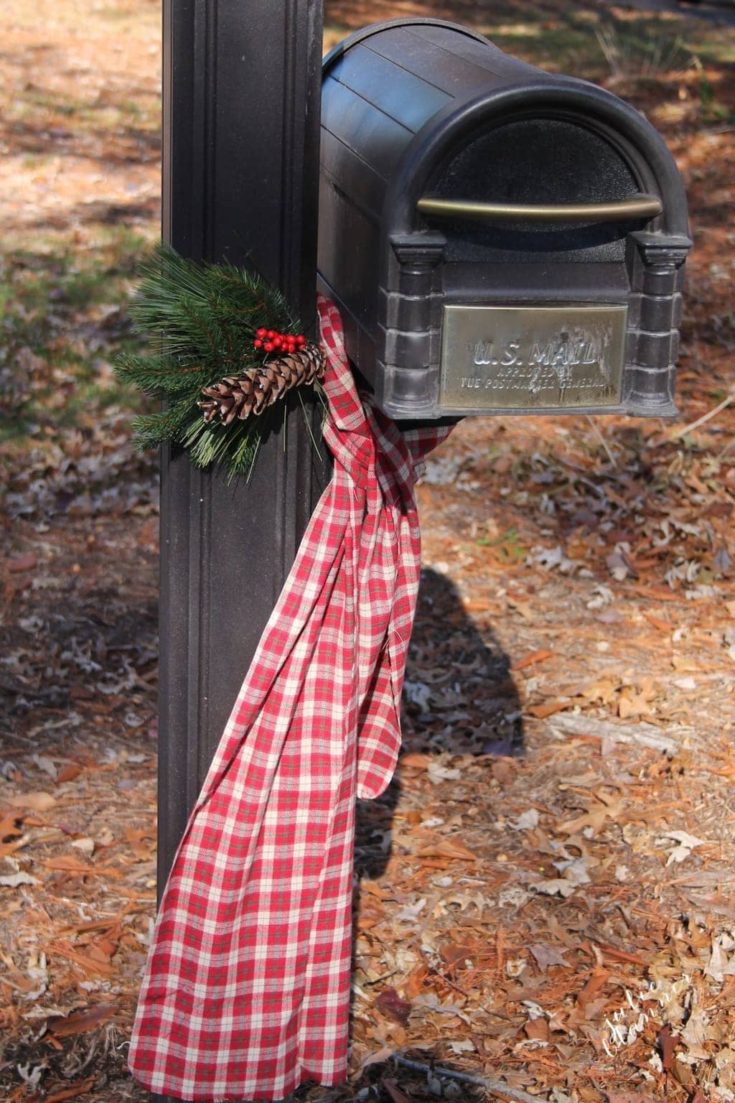 Plaid scarf with pine cones and greenery on a black mailbox