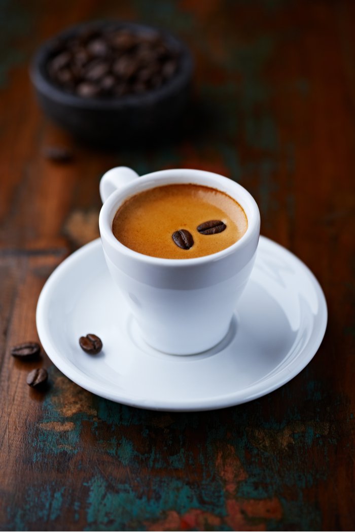 An espresso shot with espresso beans on top. An espresso shot with espresso beans on top for National Espresso Day.