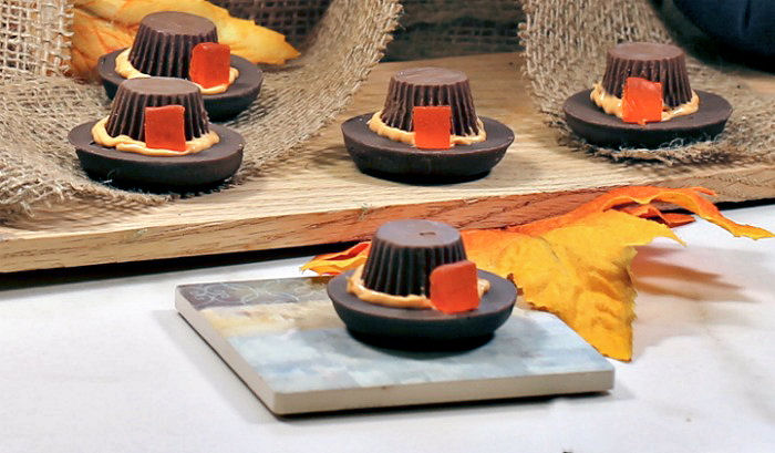 Pilgrim hat cookies. Pilgrim hat cookie treats with leaves and a wooden board.