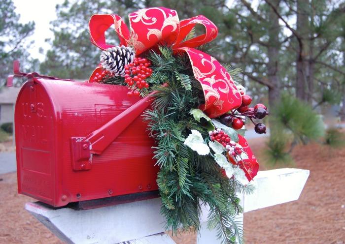 Red mailbox with Christmas garland Red mailbox decorated with a bow and garland.