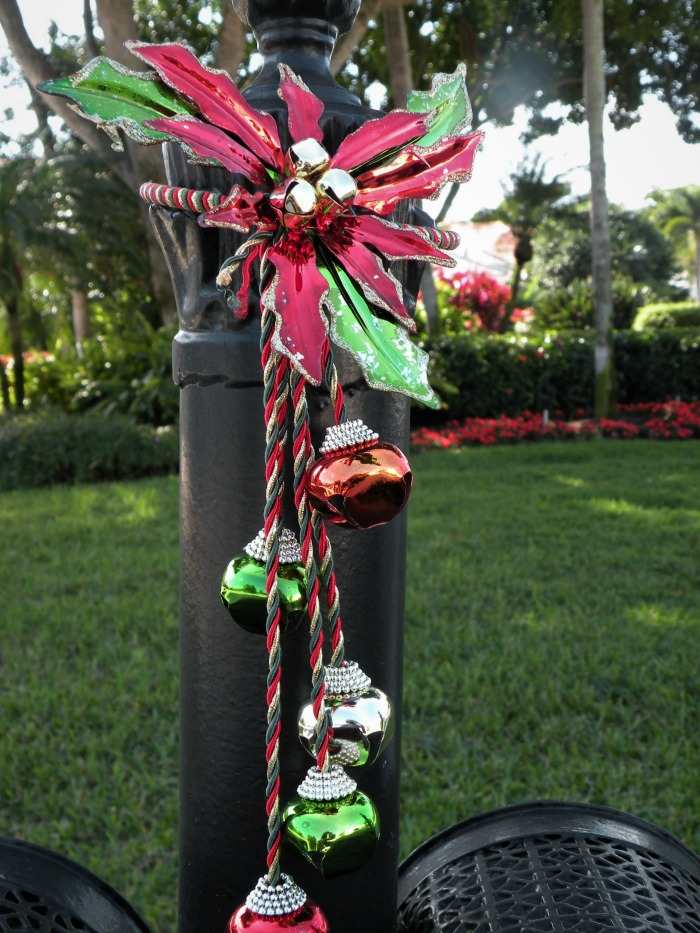Mailbox pole with Christmas bells and poinsettia Black mail box pol decorated with Christmas ornaments.