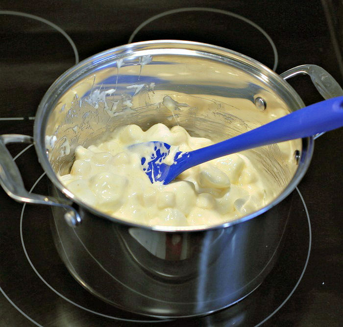 melting marshmallows. Melted marshmallows in a pot with a blue silicone spoon.
