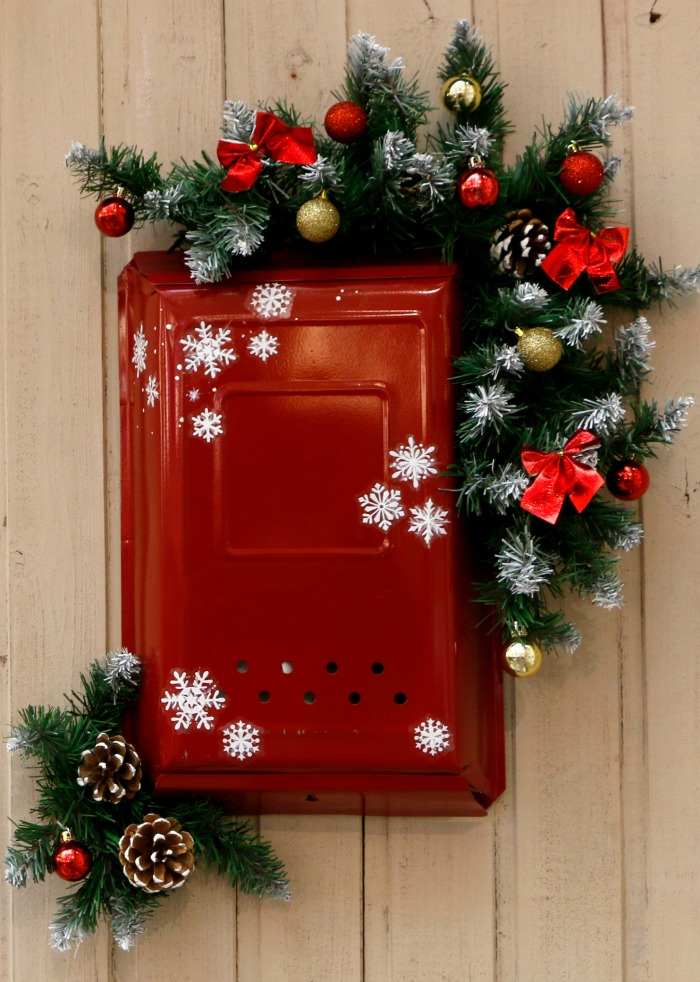 Stickers and decorations on a red mailbox Red mailbox with garland and snowflakes