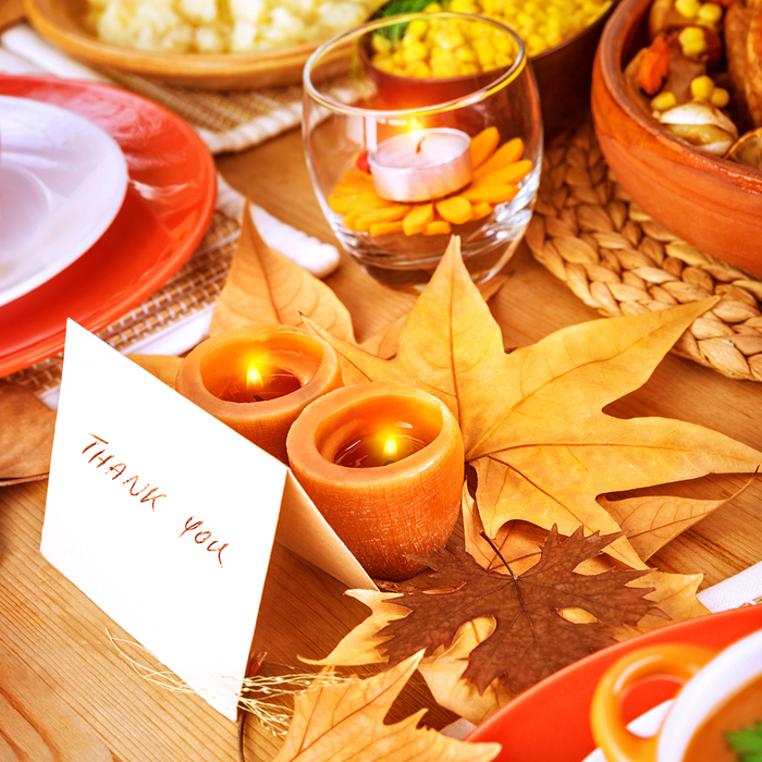A "thank you" place card on a decorated Thanksgiving table.