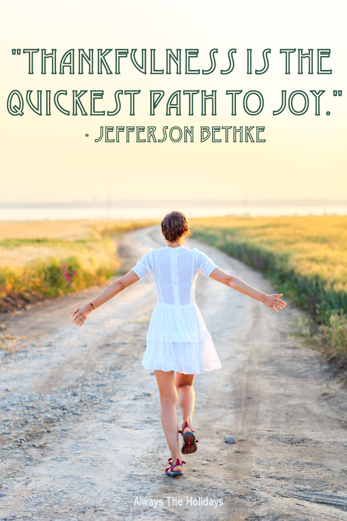 A girl wearing a white dress walking down a dirt path in the sunset with a grateful Thanksgiving quotes text overlay reading "Thankfulness is the quickest path to joy.".