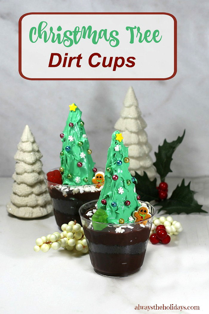 Christmas tree dirt cups. Dirt pudding with Christmas trees, with porcelain white trees, holly and words reading "Christmas tree dirt cups."