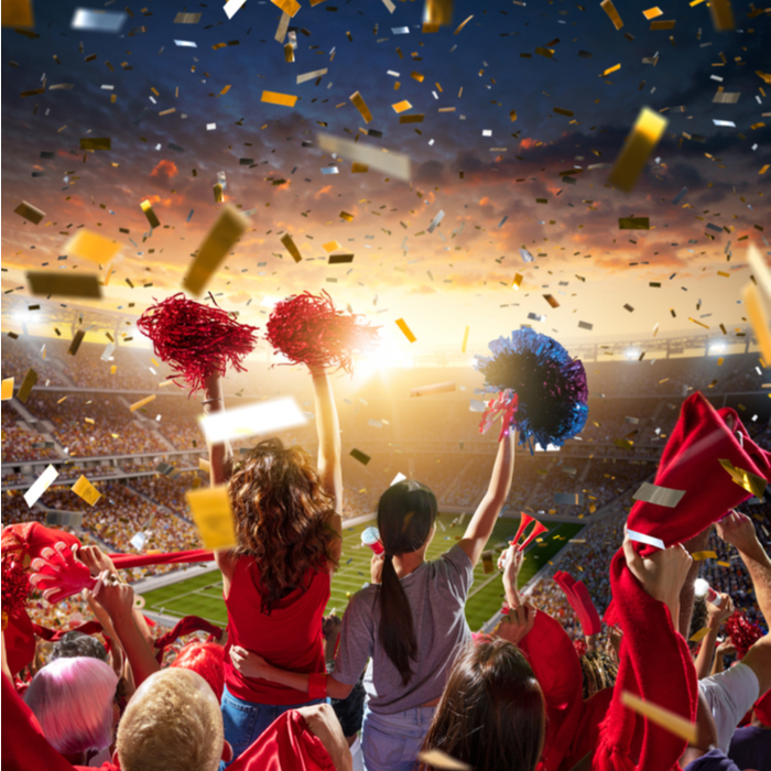 People cheering for each other, and celebrating success on New Year's in a football stadium.