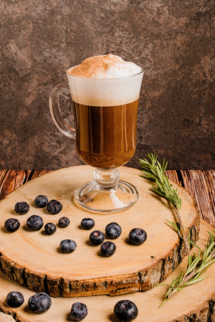 Irish coffee on a wooden board with blueberries. Irish coffee on a wooden board with blueberries celebrating Irish coffee history.