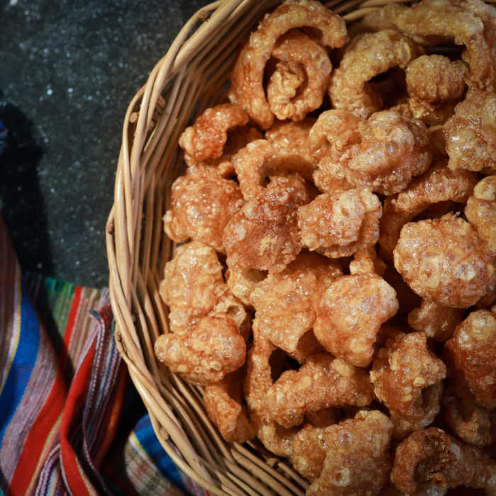 Bowl of pork rinds and a striped towel.