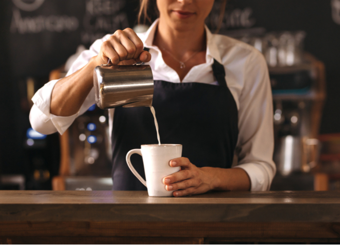 A barista making a cafe au lait to end the cafe au lait vs latte debate.