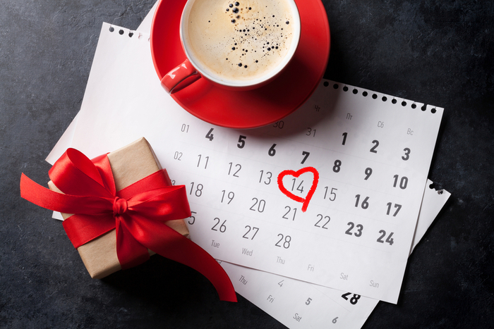 Hot chocolate and a wrapped present on a national days in February calendar with Valentine's Day circled.