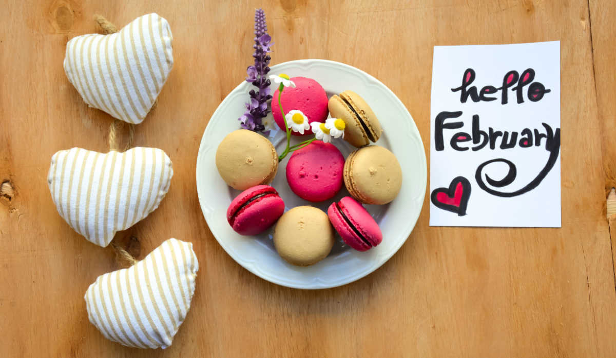 Welcome February with food. Macarons on a plant with hearts and words Hello February.